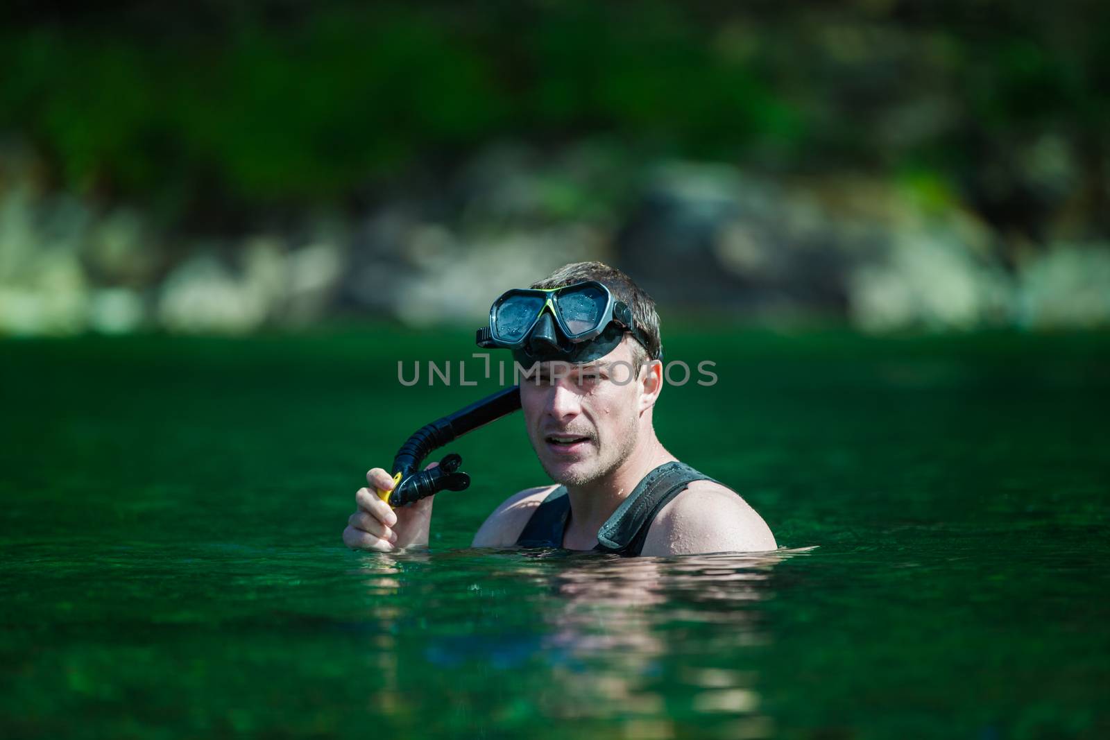 Young Adult Snorkeling in a river with Goggles and Scuba.