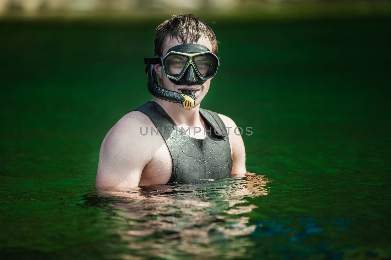 Funny Young Adult Snorkeling in a river with Goggles and Scuba.