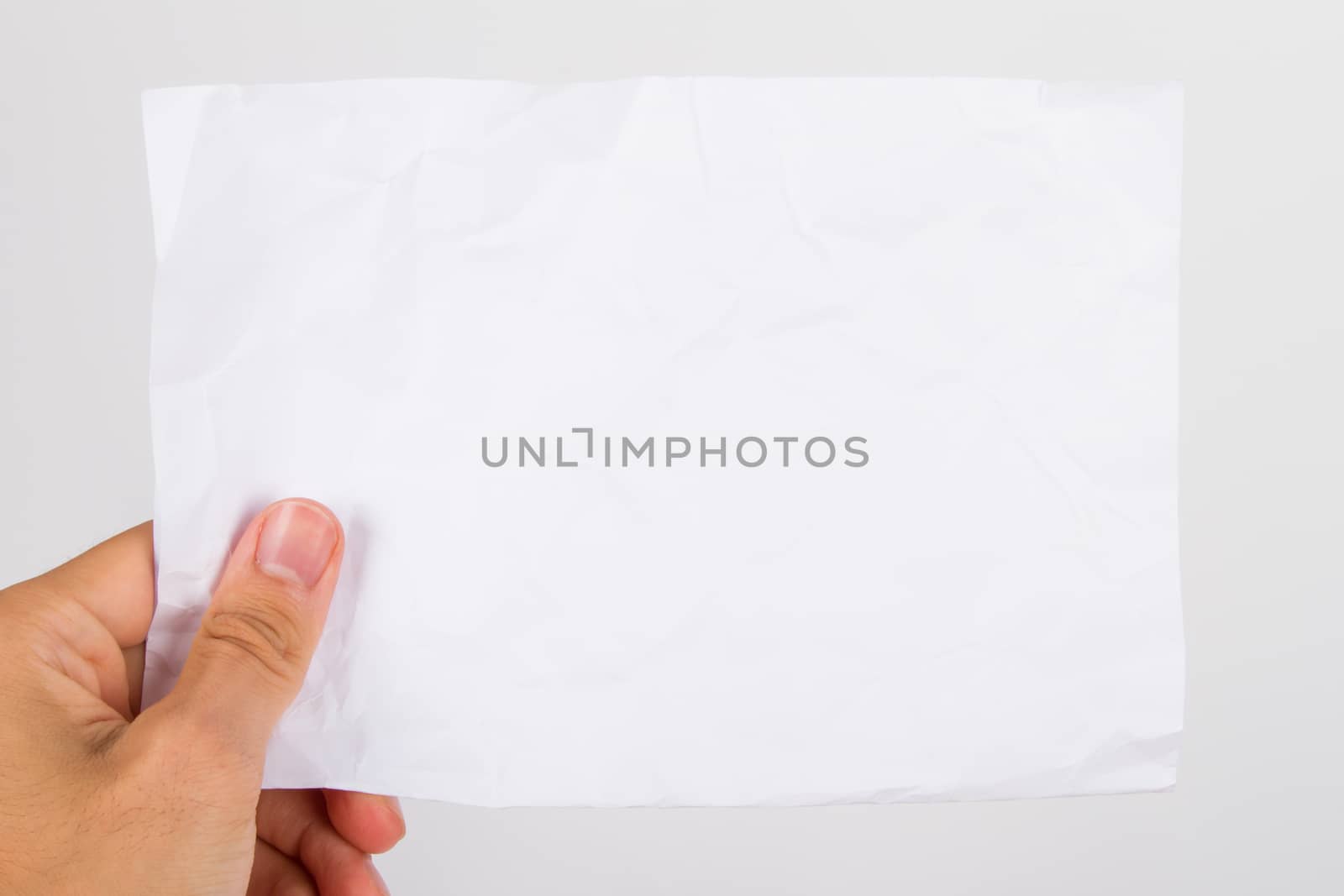 Hand holding grunged, crumpled, blank paper, isolated on white background.