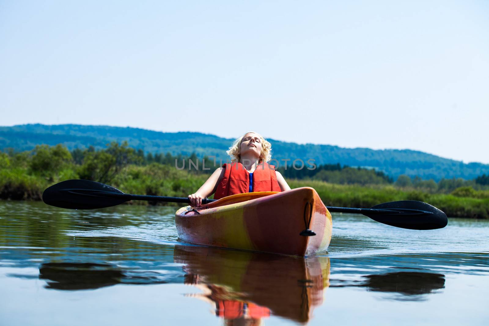 Young Woman Relaxing on a Kayak and Enjoying the Moment of Freedom