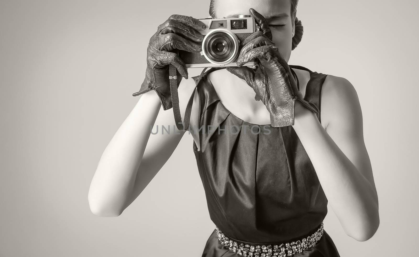 Fashion portrait of beautiful young girl in classic vintage style with an analogue photo camera