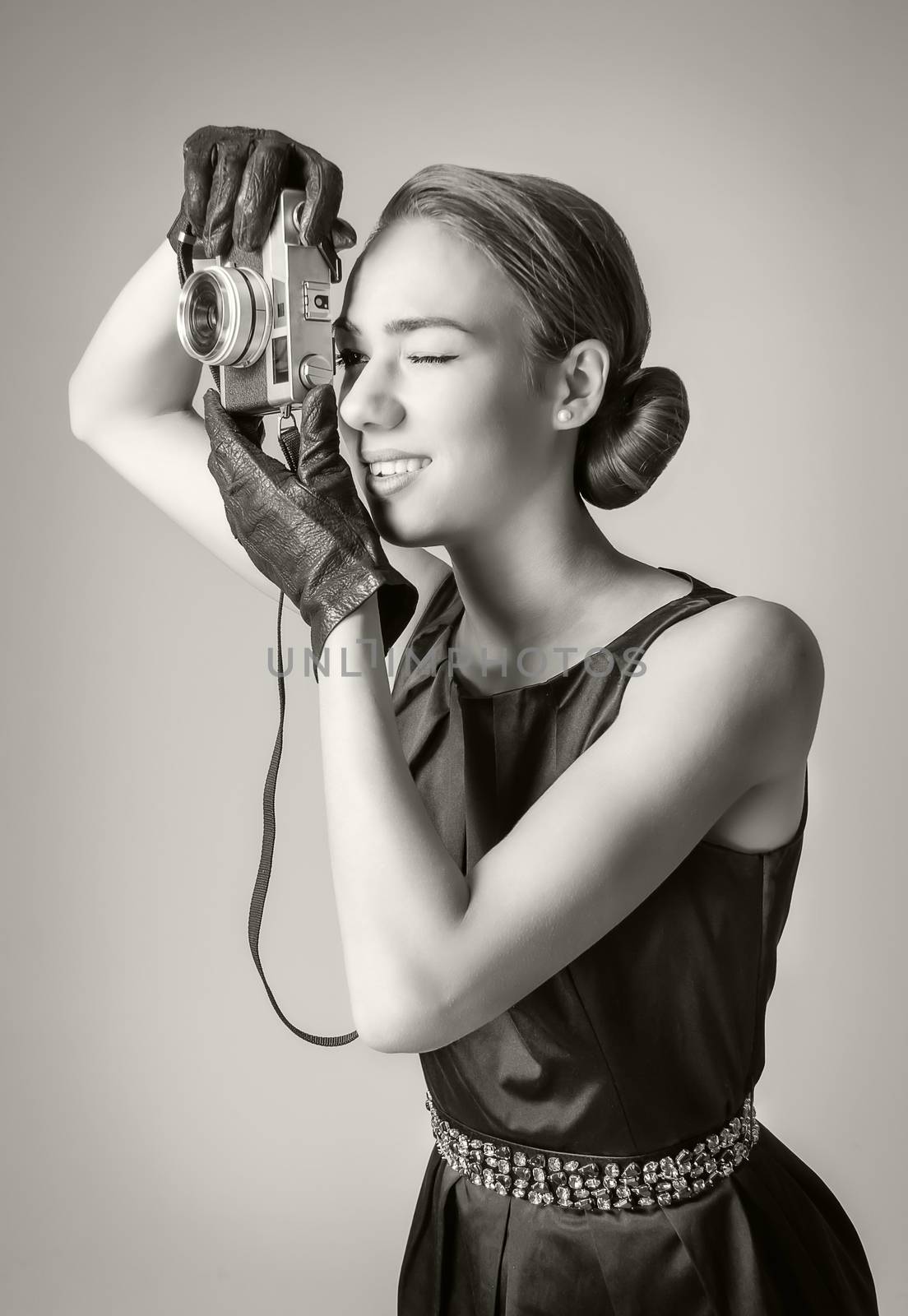 Fashion portrait of beautiful young girl in classic vintage style with an analogue photo camera