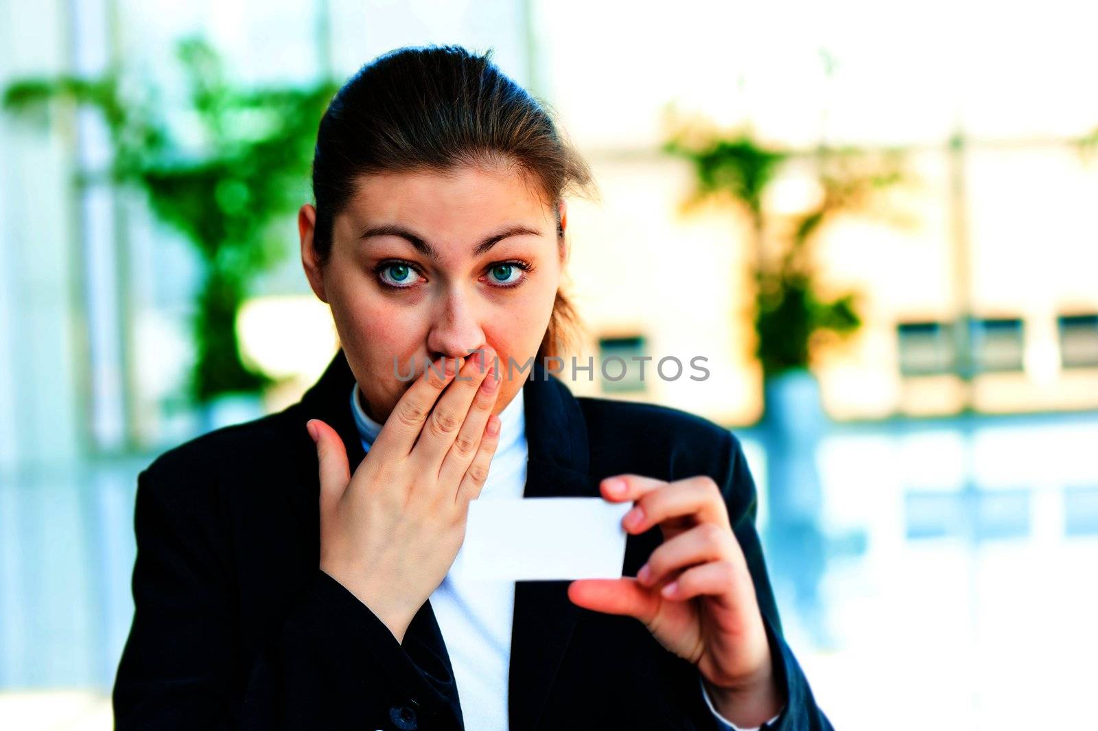 Dark-haired businesswoman with surprise looks at the business card by kosmsos111