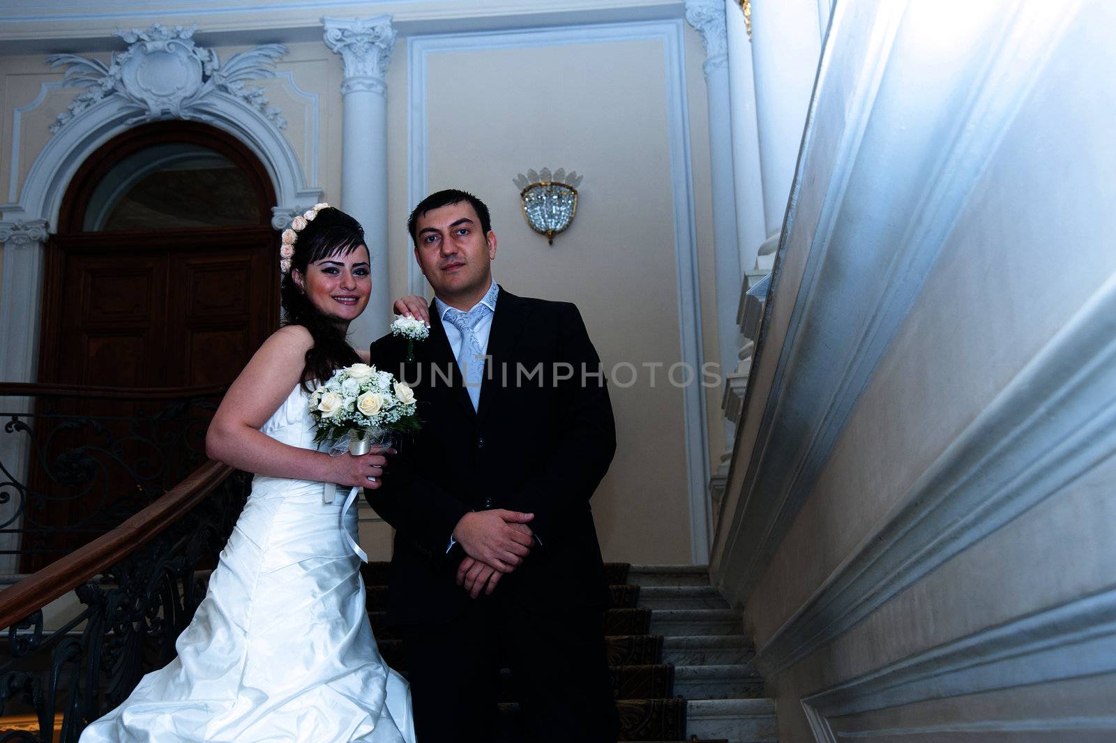  bride and groom standing on the stairs.