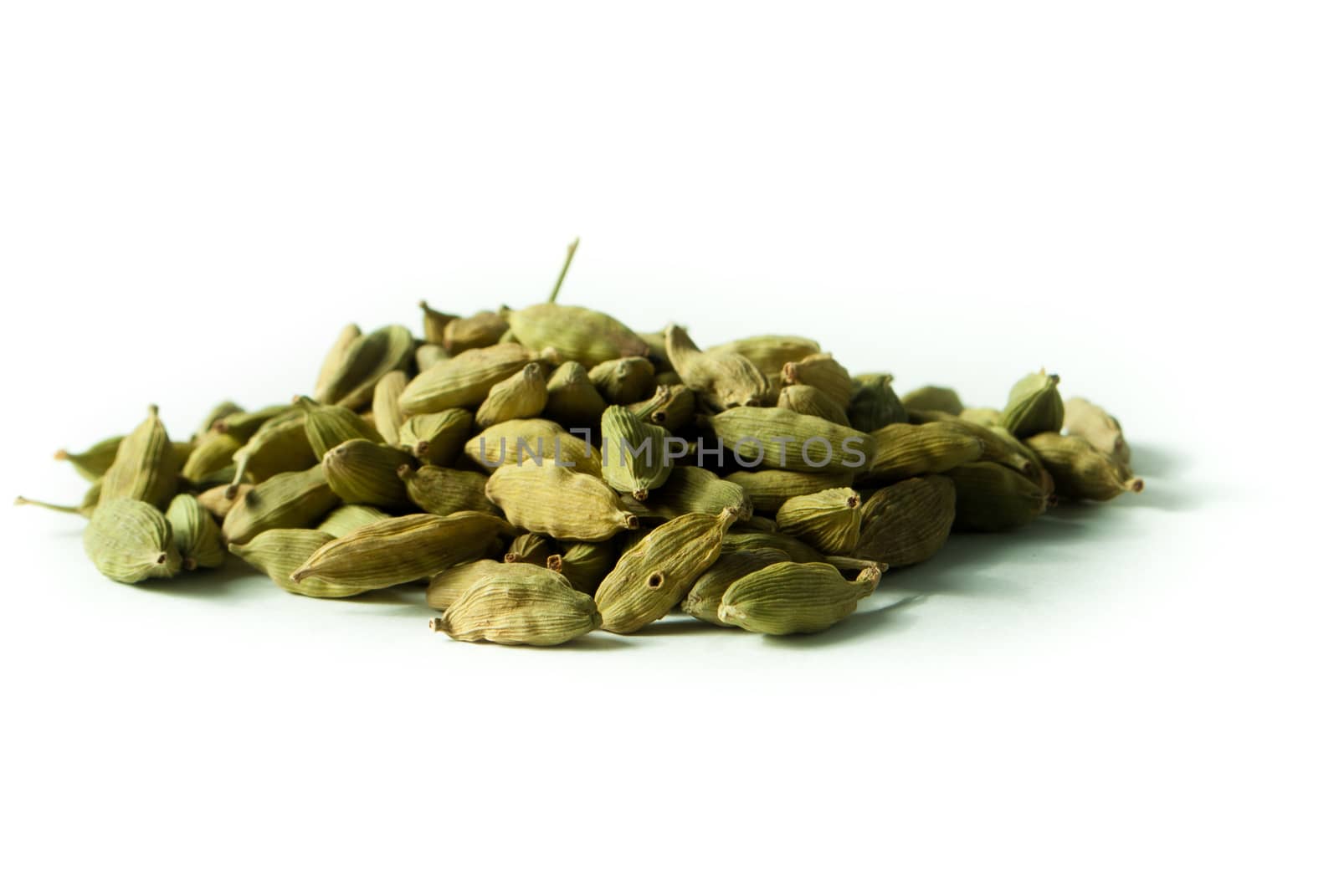 Pile of whole cardamom on white background
