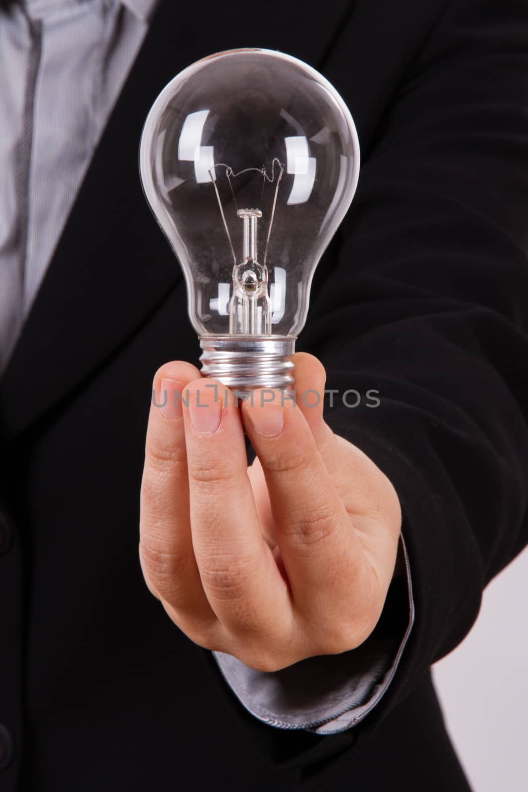 Business woman shows and holds lightbulb.