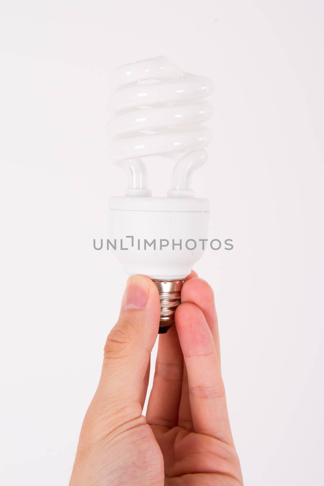 Affordable light bulb holding by male human hand on white.