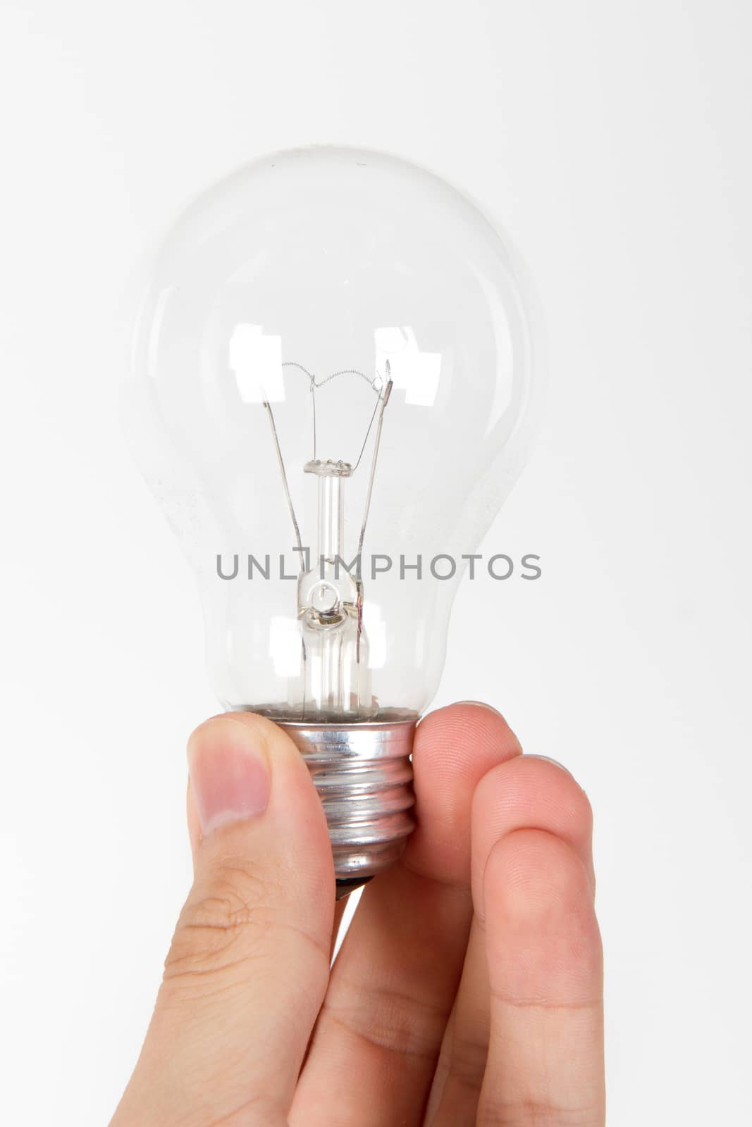 Hand holding light bulb from the bottom, on white bakcground.