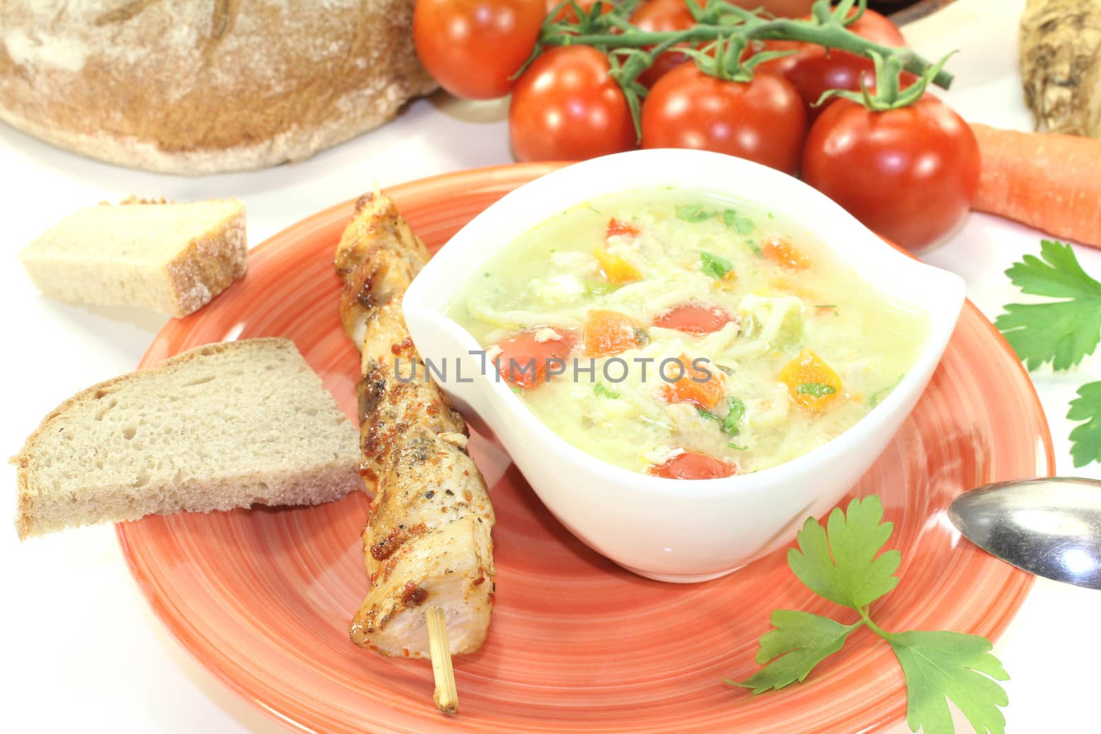 Chicken soup with eggs and noodles on bright background
