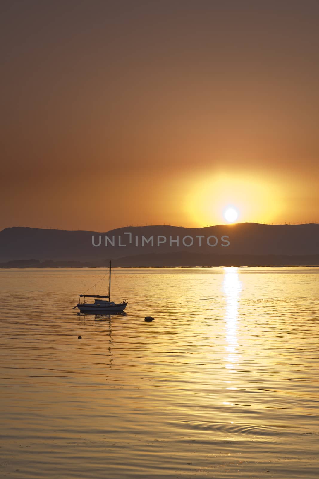 Sunset over the sea with sailing boat. Vilagarcia, Pontevedra, Spain