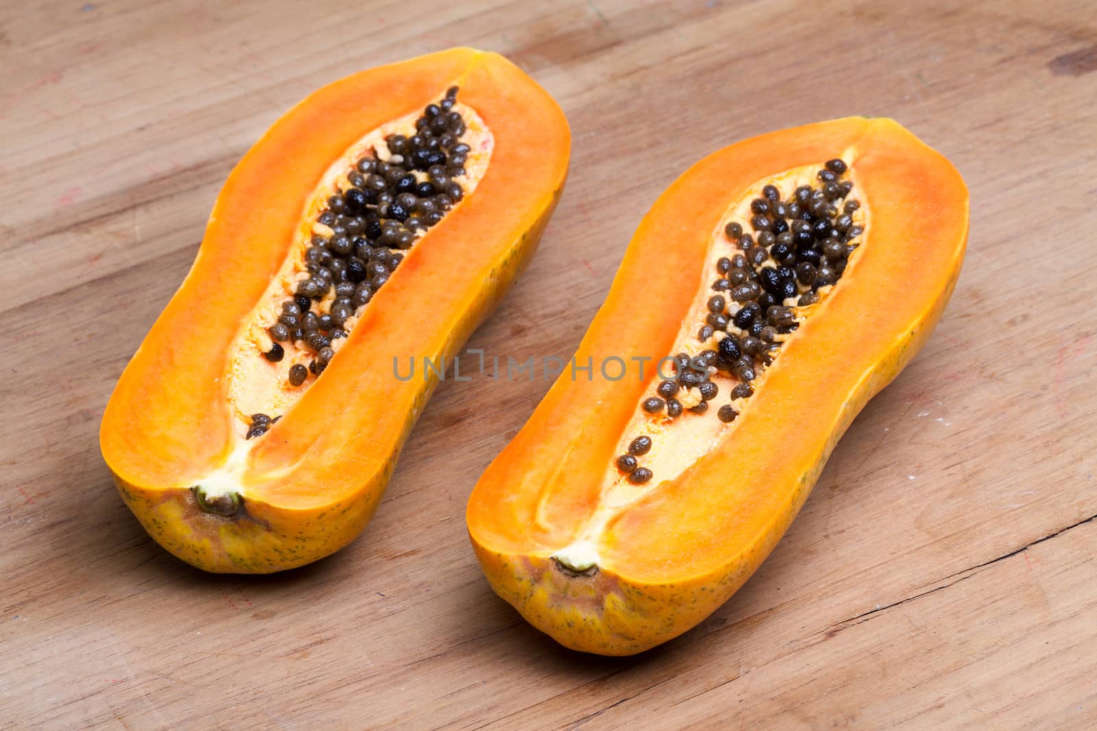 ripe fresh papaya half cut on wooden plate