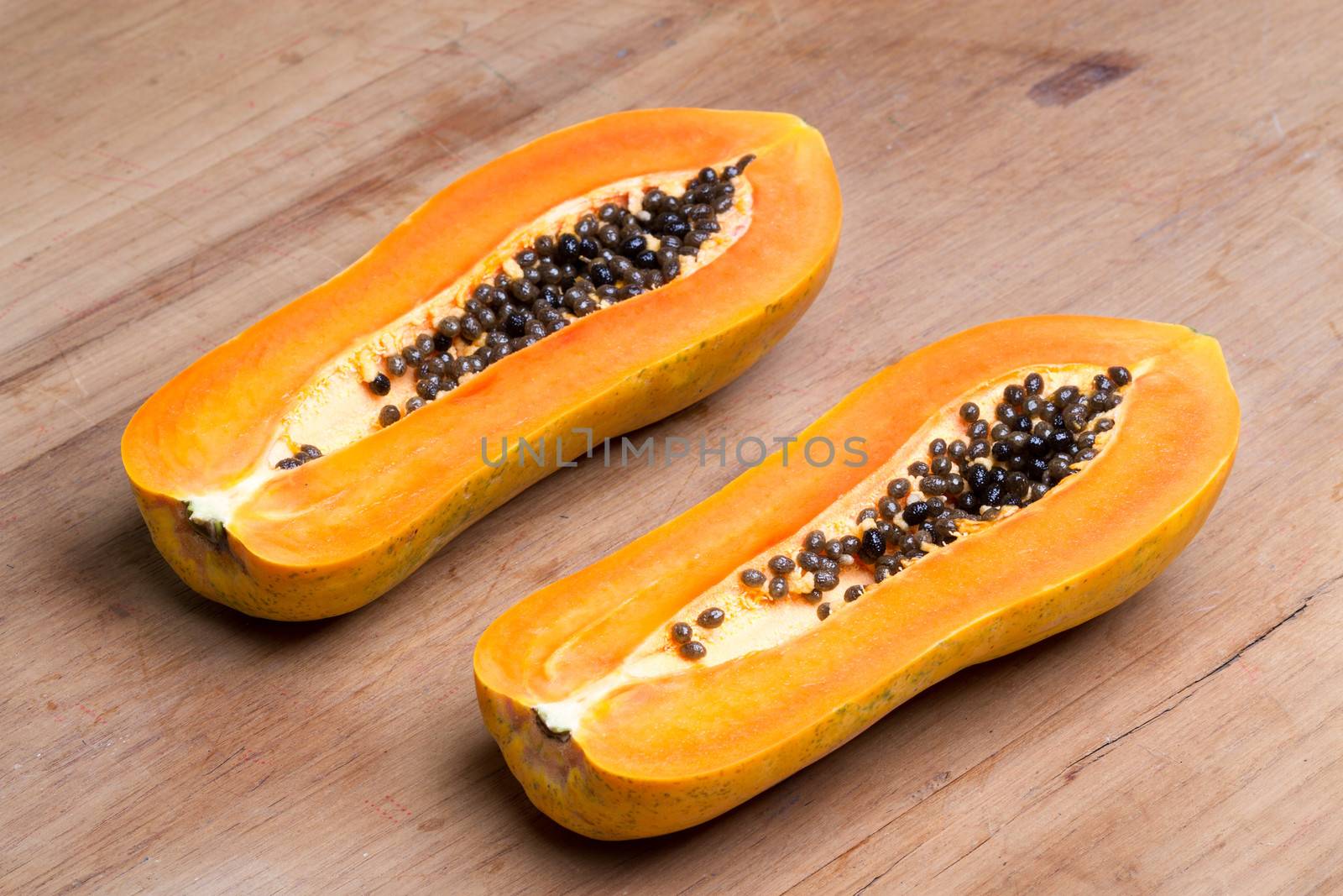 ripe fresh papaya half cut on wooden plate