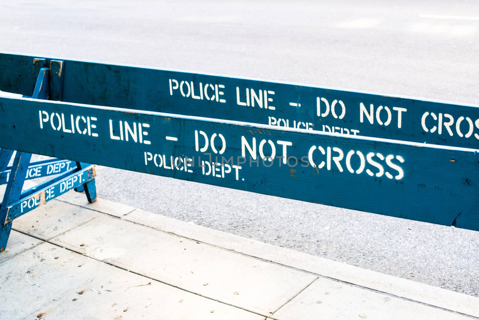 Wooden blue Police barrier saying POLICE LINE - DO NOT CROSS, POLICE DEPT.