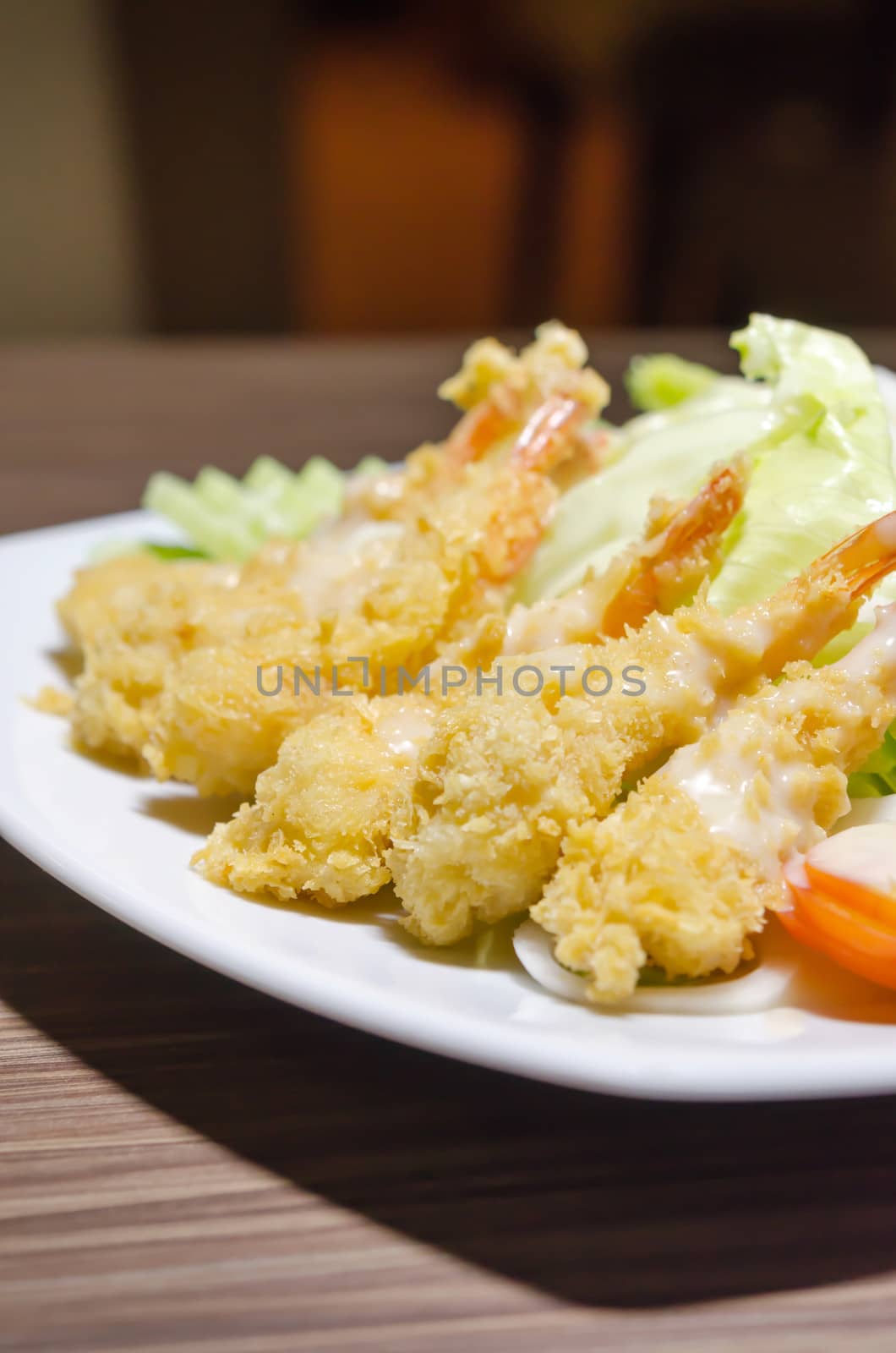 deep fried shrimp and  fresh vegetable salad with cream sauce on white dish