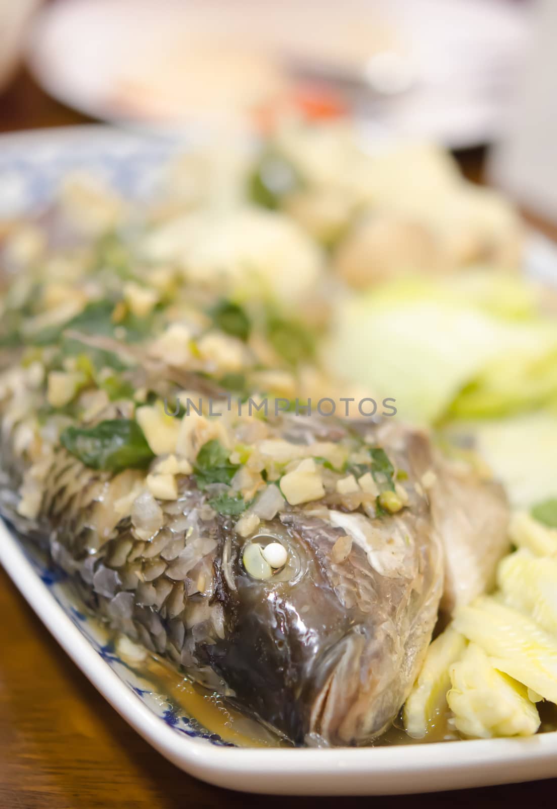 steamed fish with garlic , herbs and vegetable , asian style  seafood