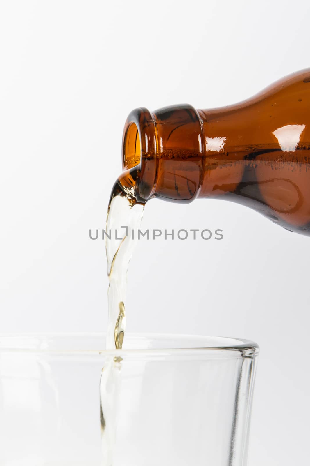 Beer pouring into glass, isolated on white background.