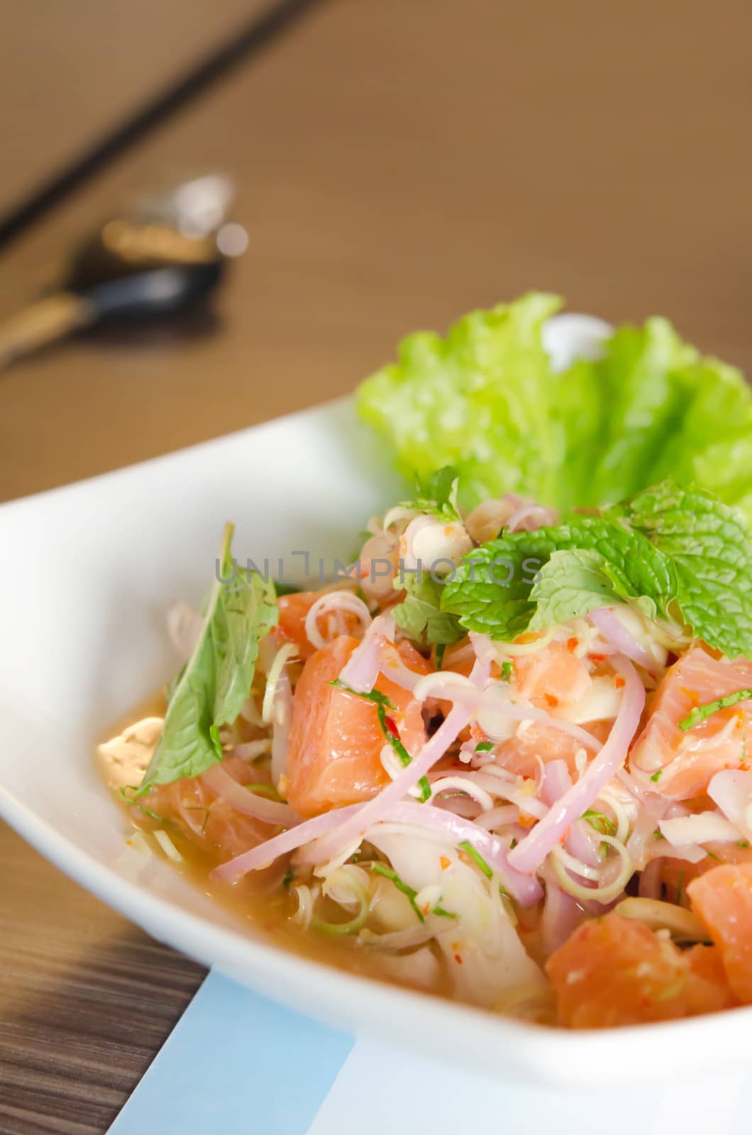 close up of salmon salad with chili and  mixed  vegetable , sour and spicy 