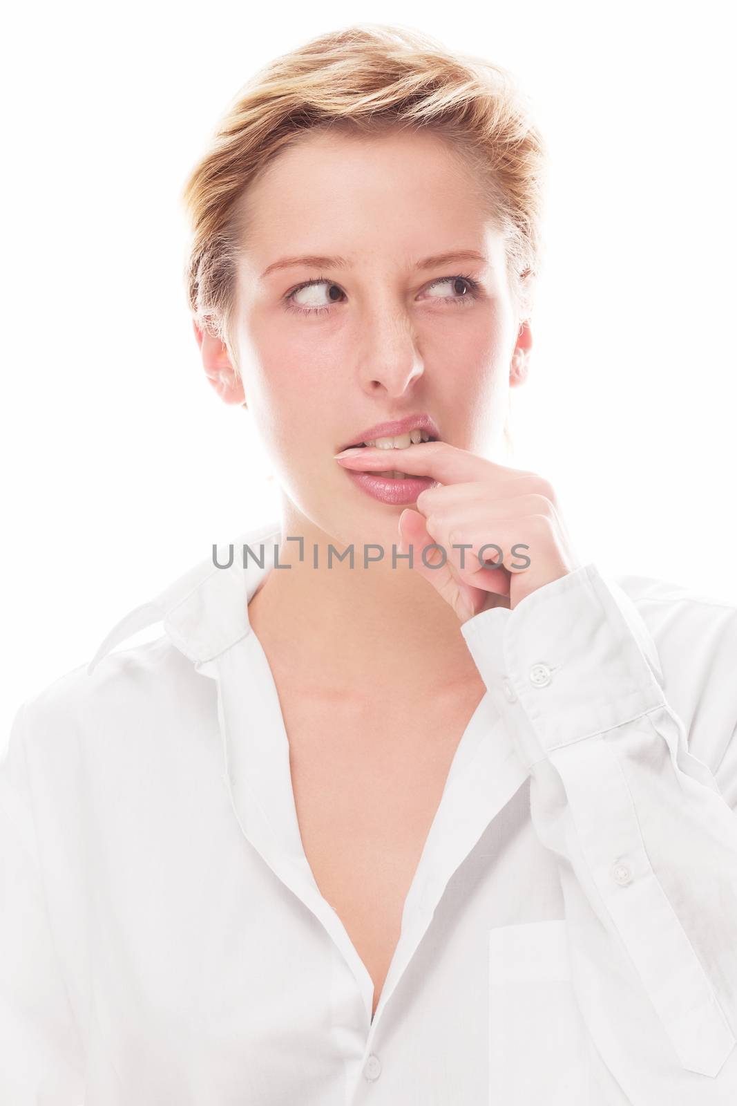 young cute woman bites in her finger looking to side on white background