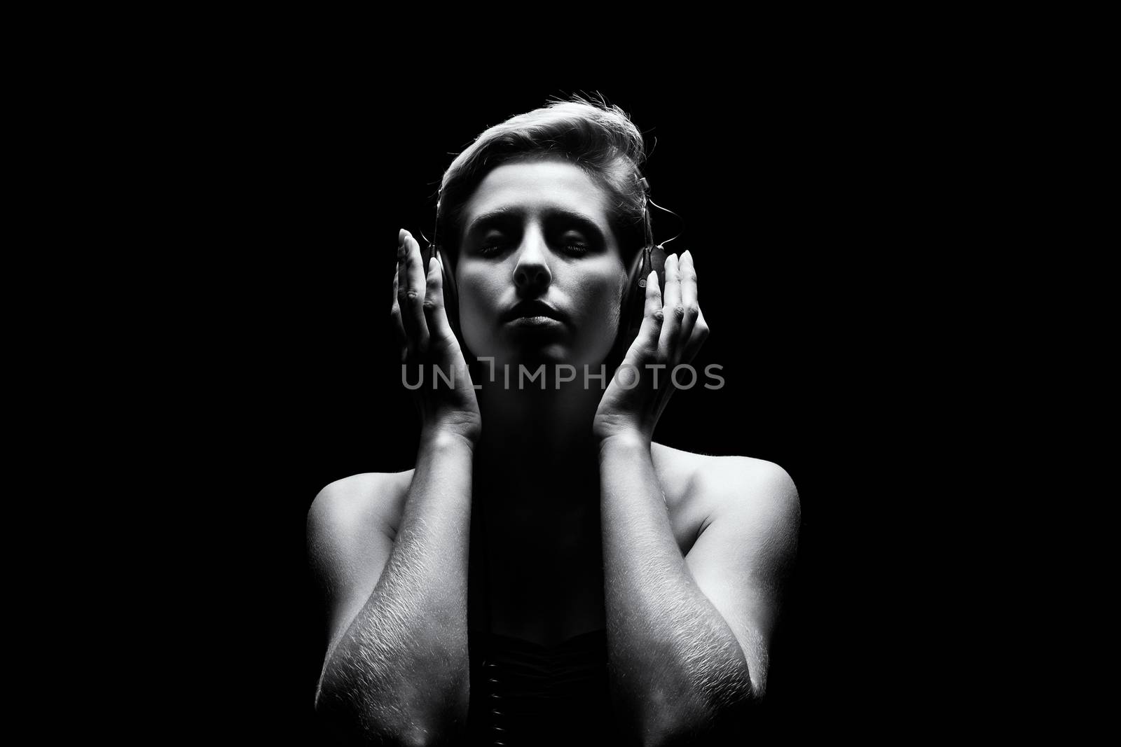 beautiful woman in tense black and white light listening to music 
