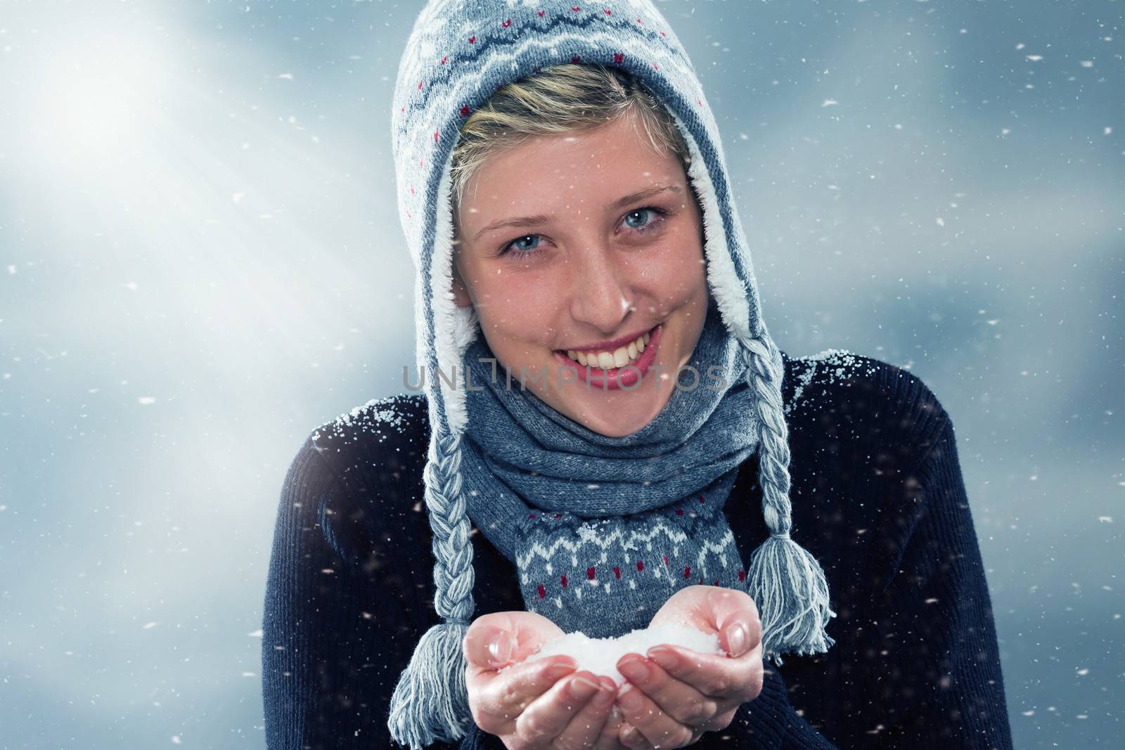 young cute woman in winter with a hand full of snow