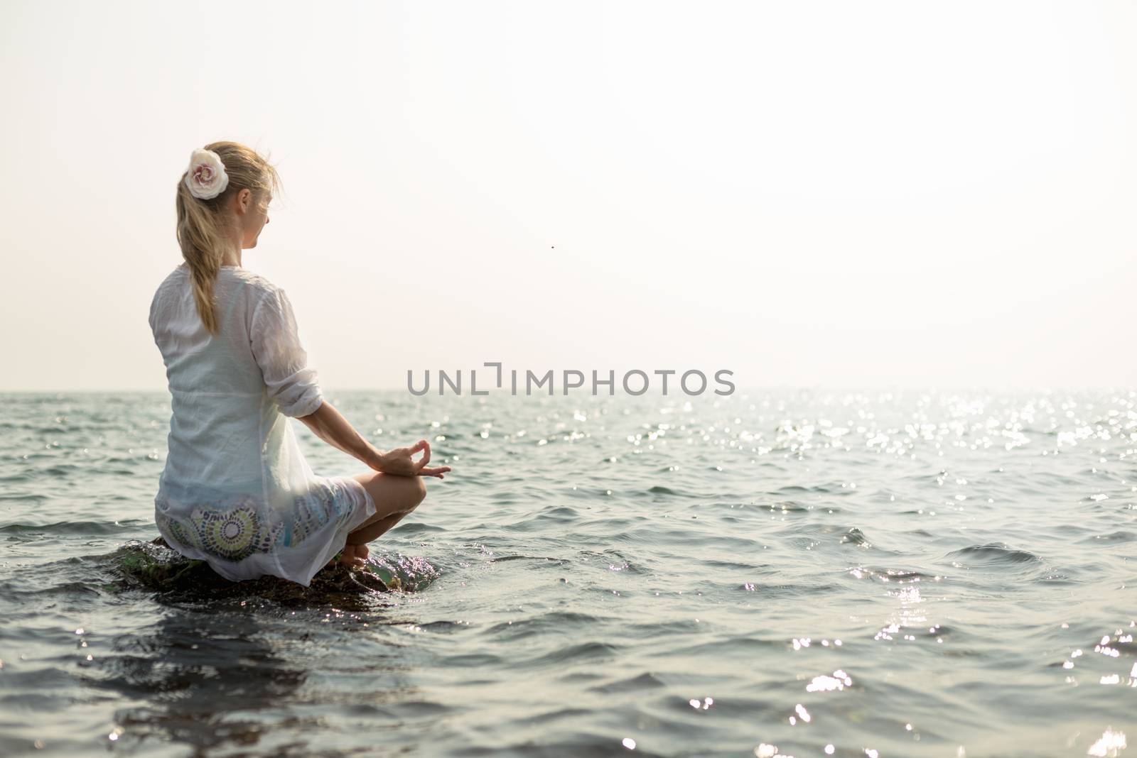 Woman meditating at the sea by Nickolya