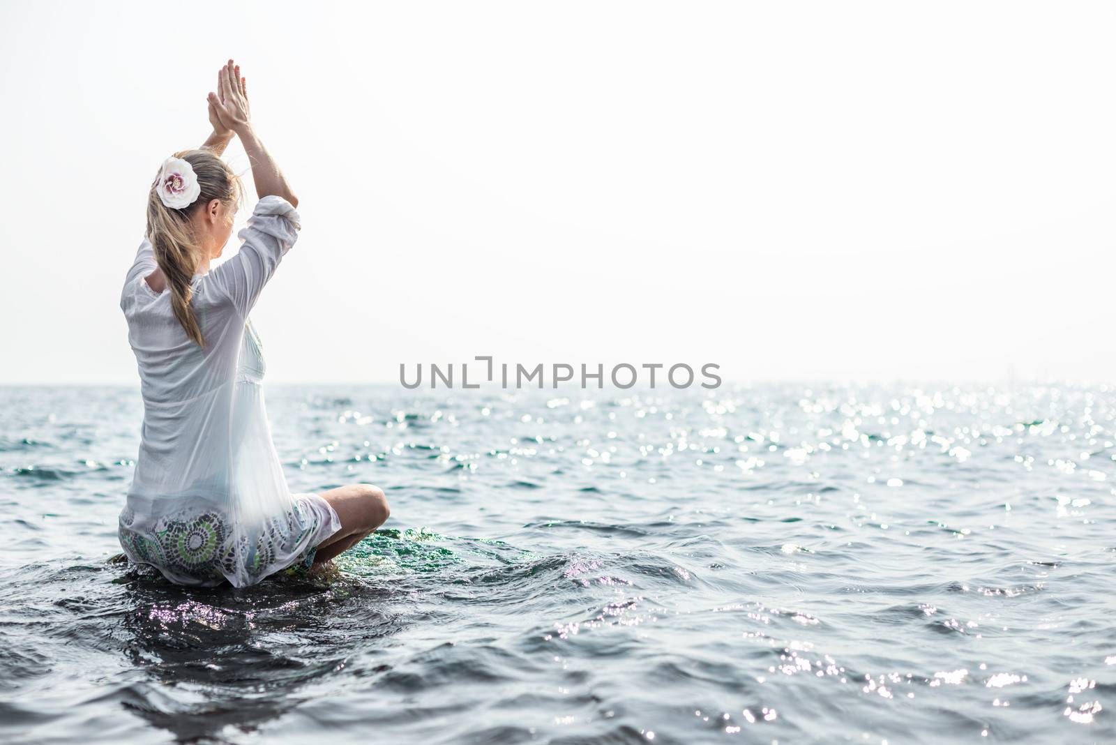 Woman meditating at the sea by Nickolya