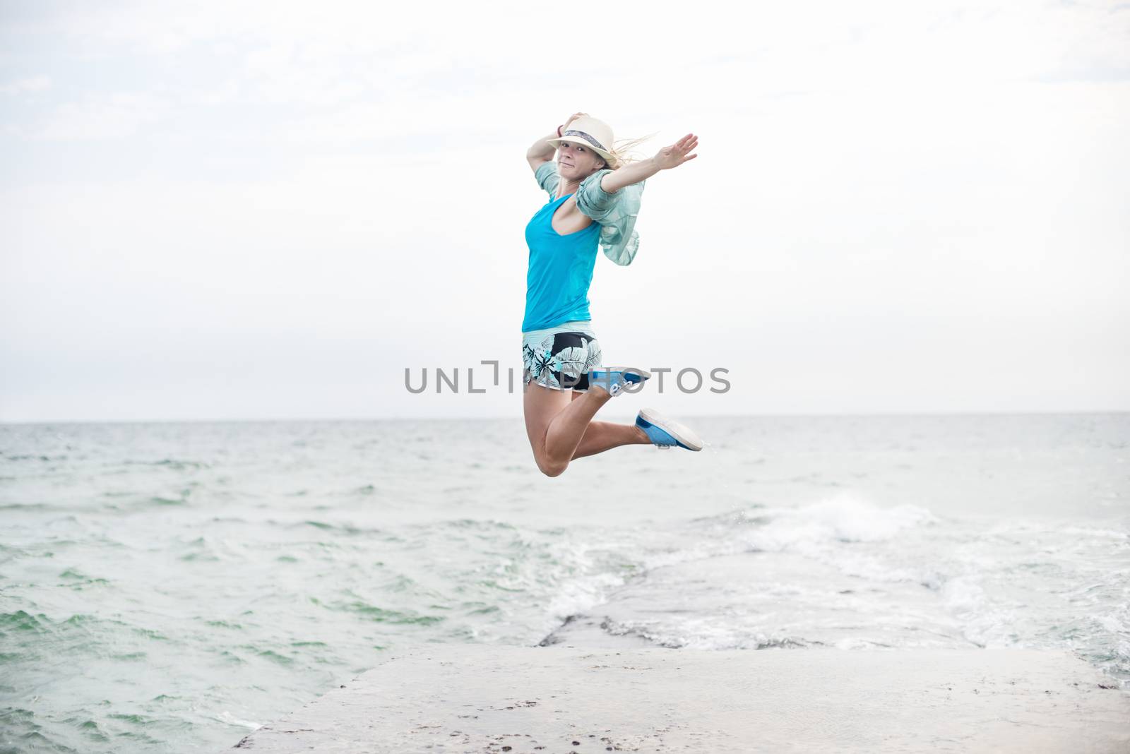 Young woman jumping on the beach by Nickolya