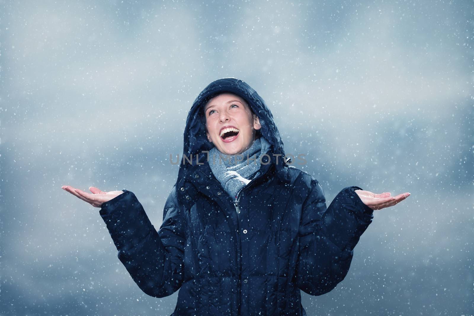 young woman wearing winter clothes  is excited about the snowfall