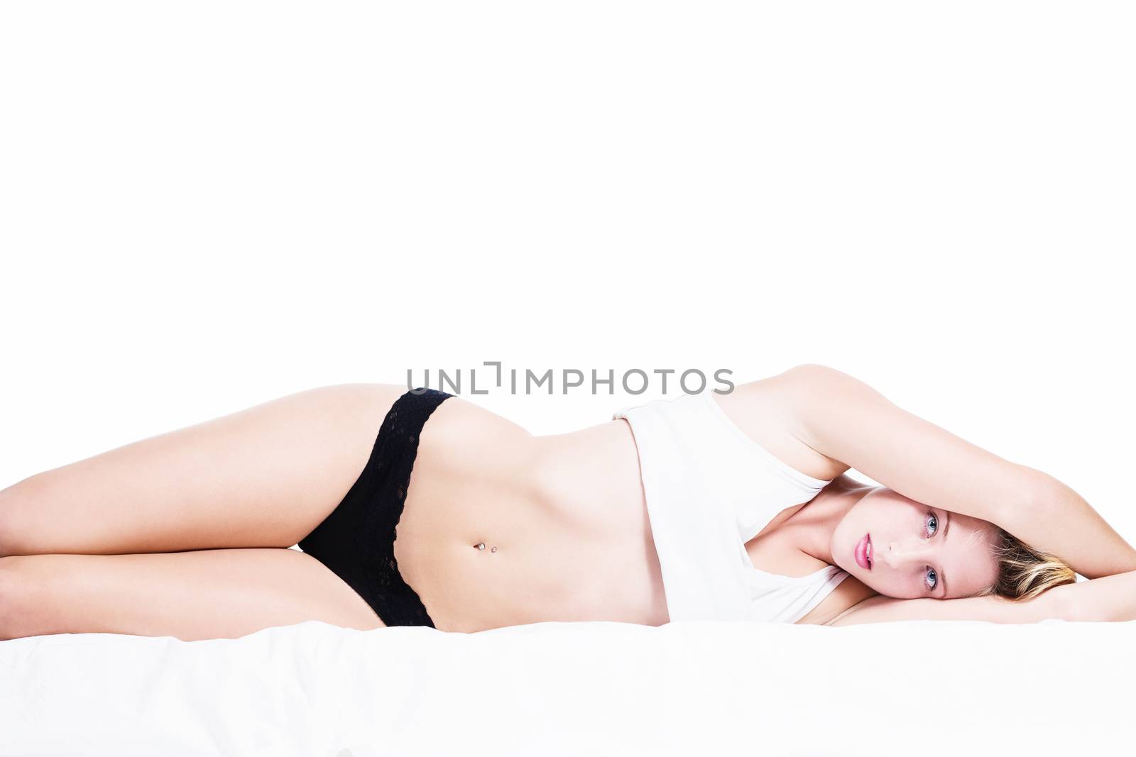 young beautiful woman in bed with arms over her head on white background