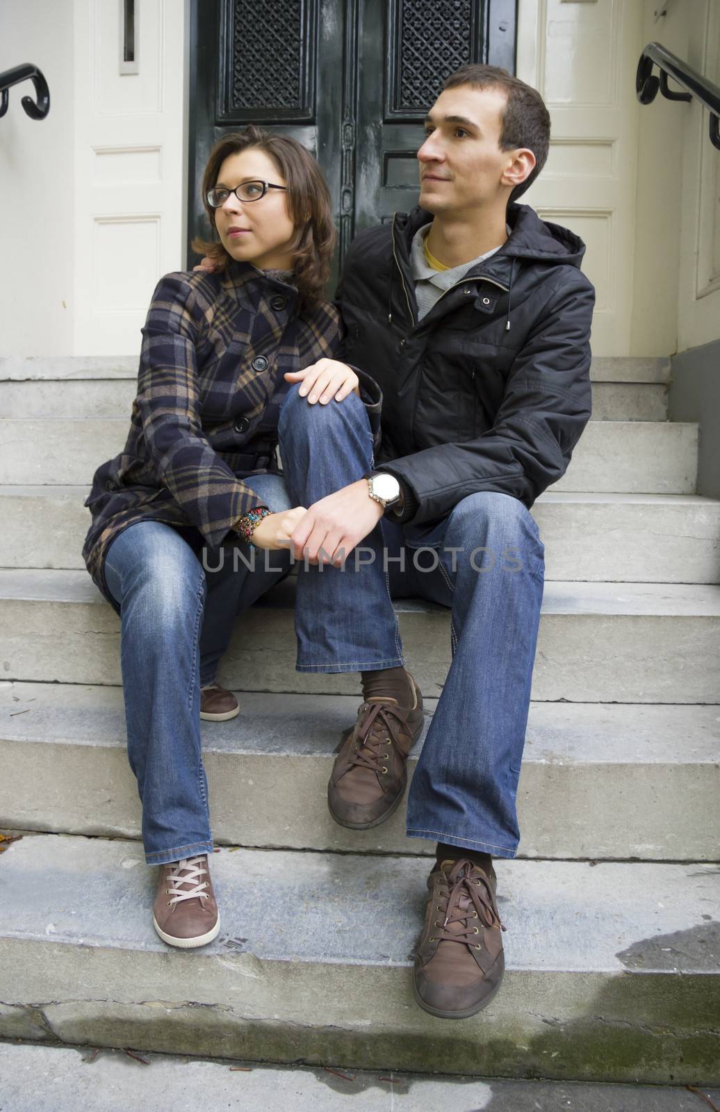 Portrait of love couple sitting on traditional Dutch porch looking happy