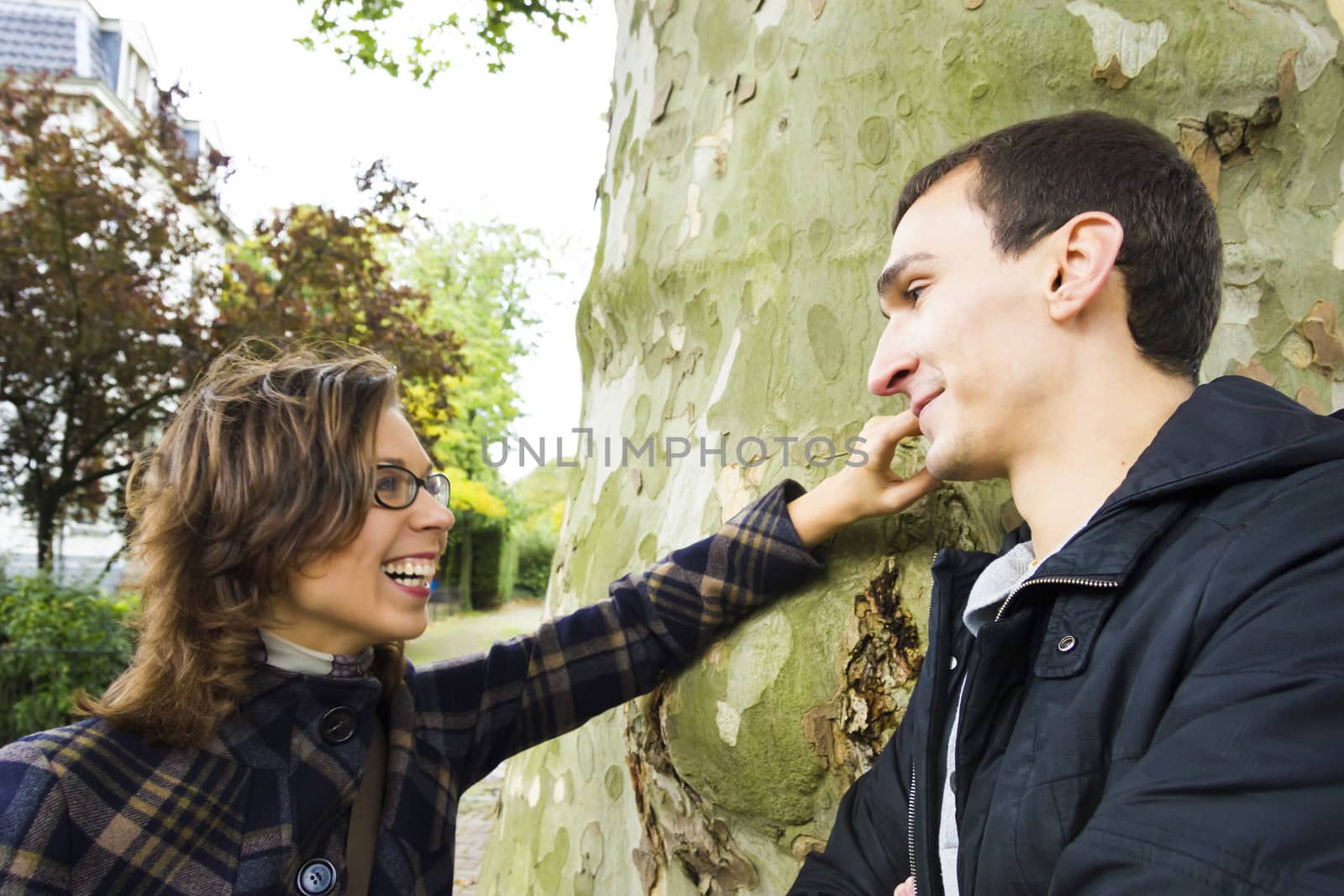 Portrait of love couple talking outdoor in park looking happy by Tetyana