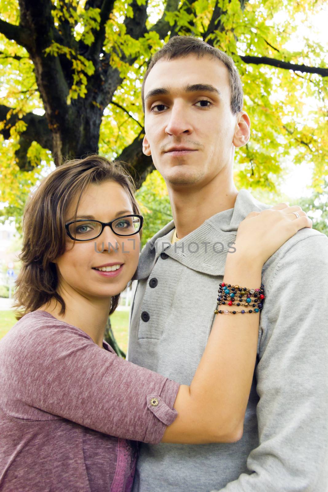 Portrait of love couple embracing outdoor looking happy