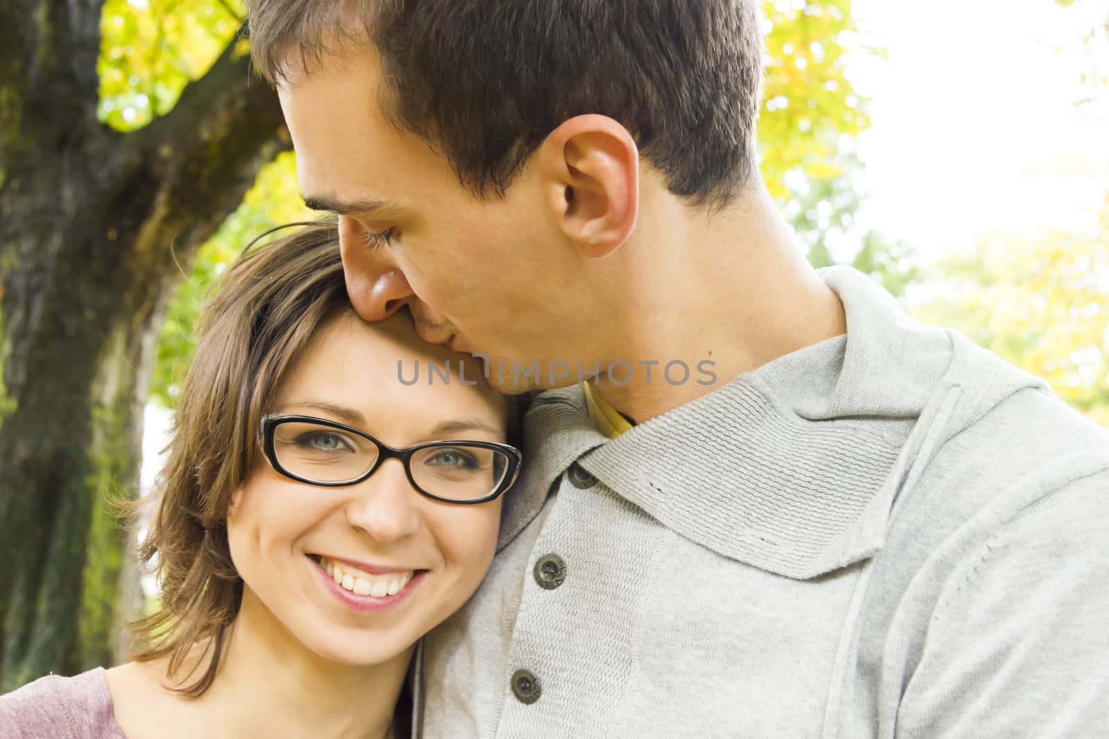 Portrait of love couple embracing outdoor looking happy