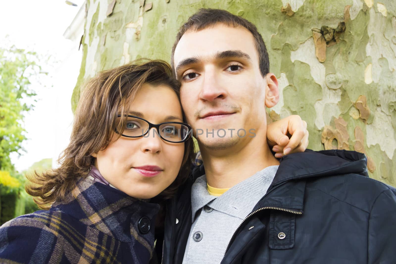 Portrait of love couple embracing outdoor looking happy