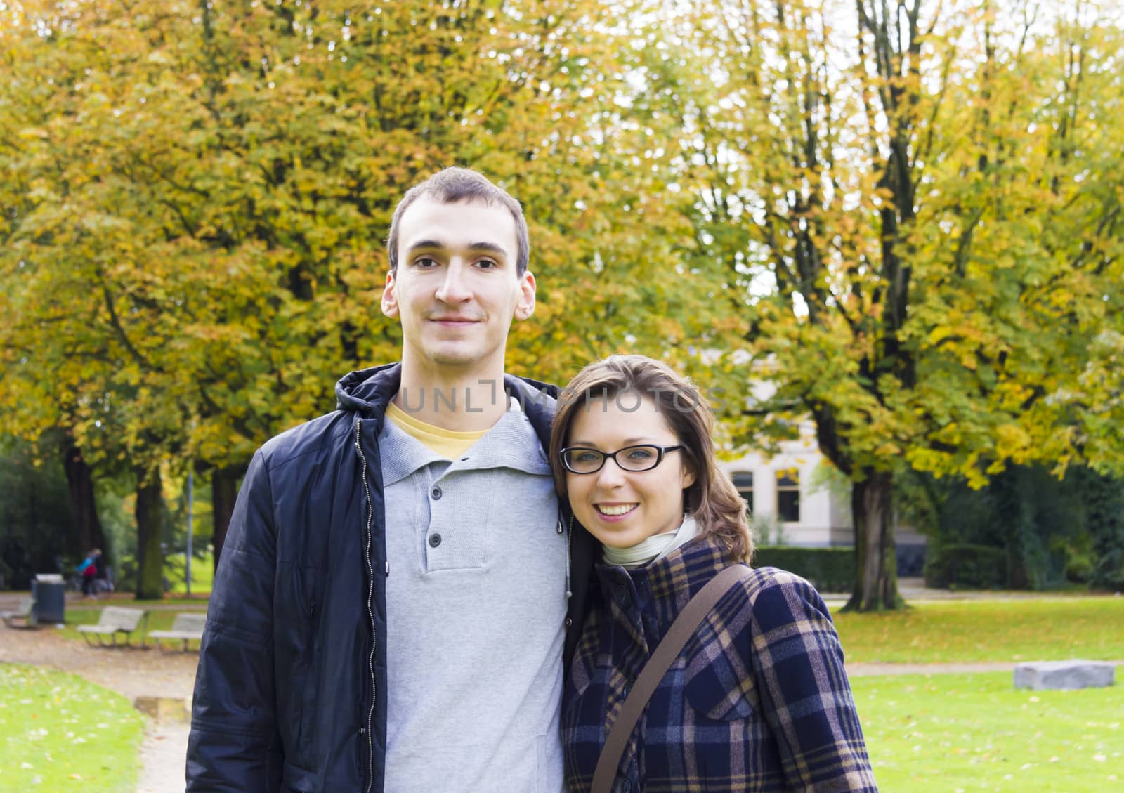 Portrait of love couple embracing outdoor in park looking happy