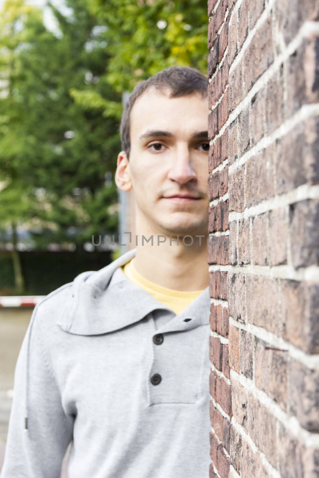 Man peeking from behind a wall corner by Tetyana