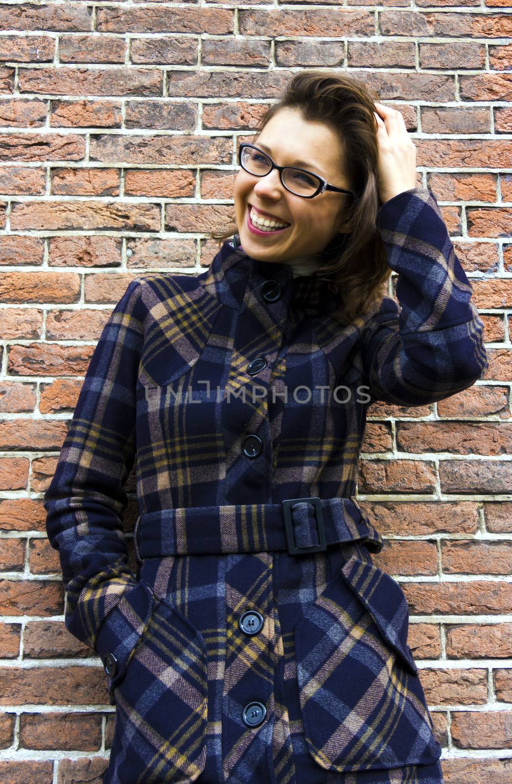 portrait of  young smiling woman on brick wall background by Tetyana