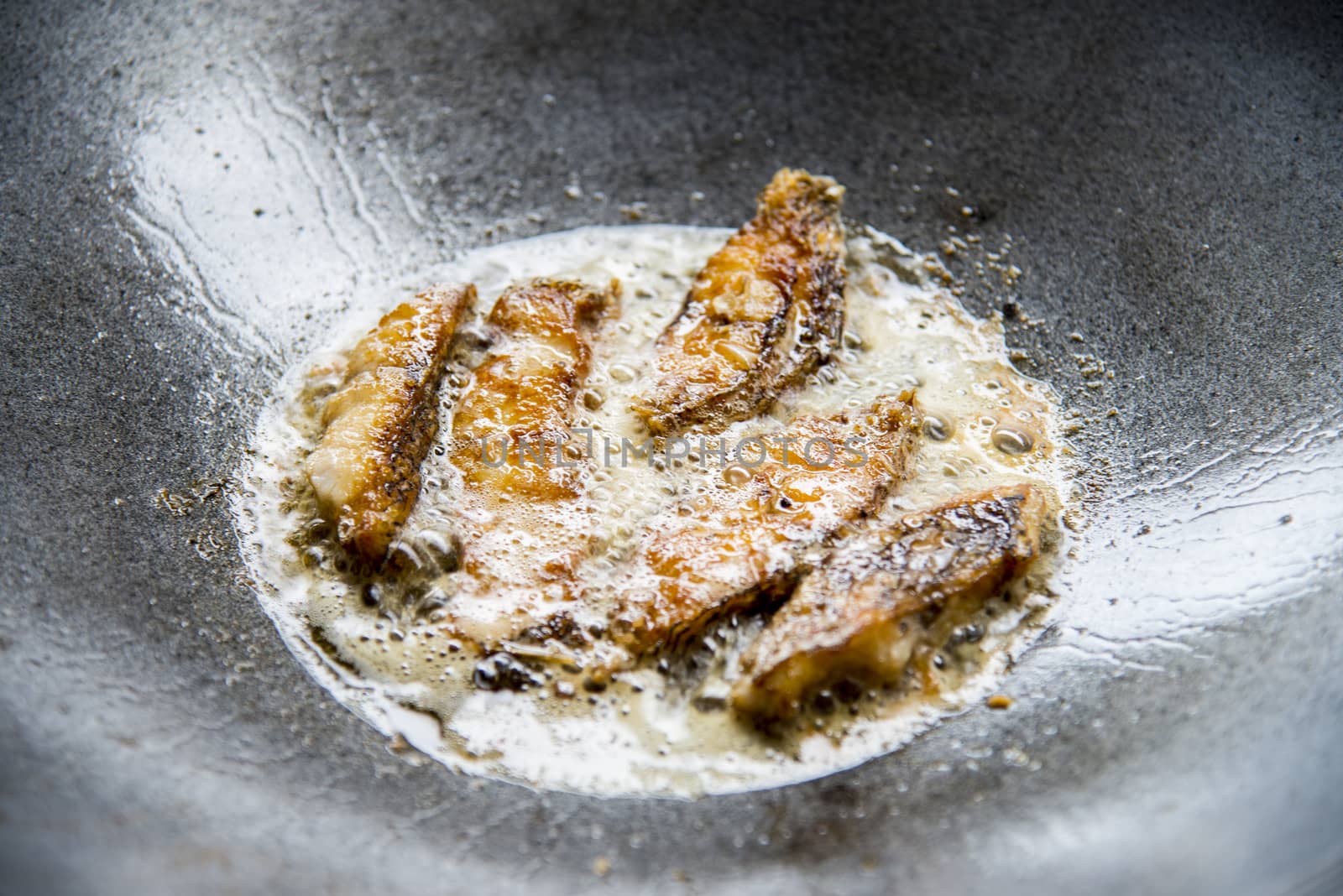 Fried pieces of fish in a pan1 by gjeerawut