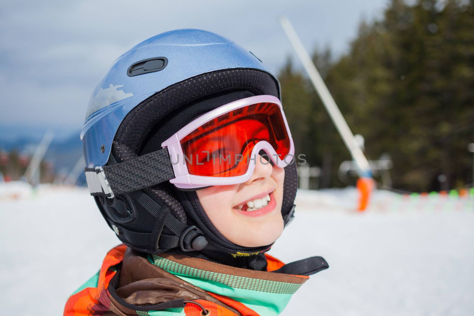 Portrait of girl in helmet and ski goggles on a sunny day in the mountains