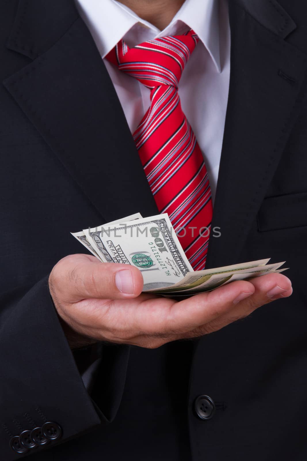 Businessman with red tie holding money on his hand.