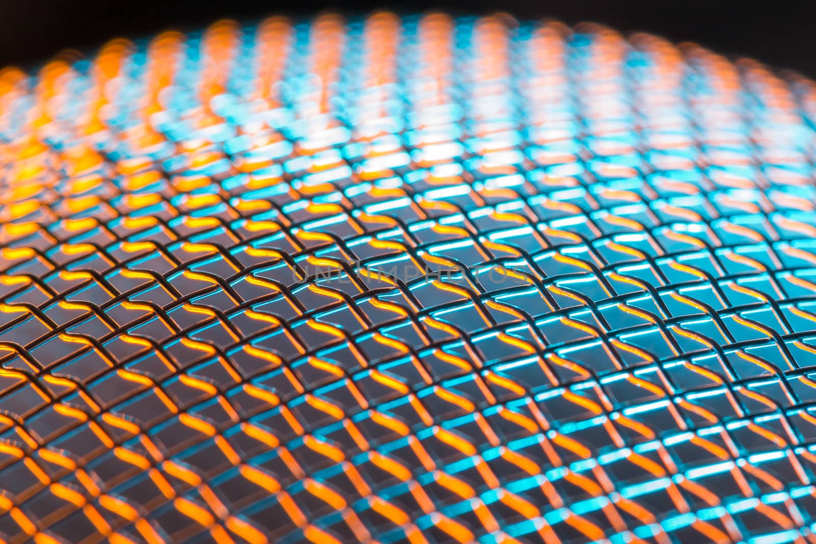 Steel net sphere lit in blue and orange. Shallow depth of field