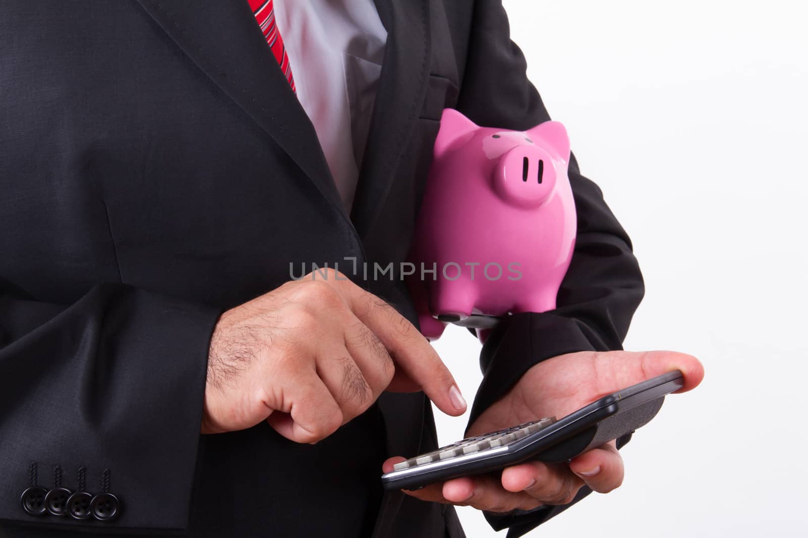 Businessman holding pink piggy bank and calculator, isolated on white background.