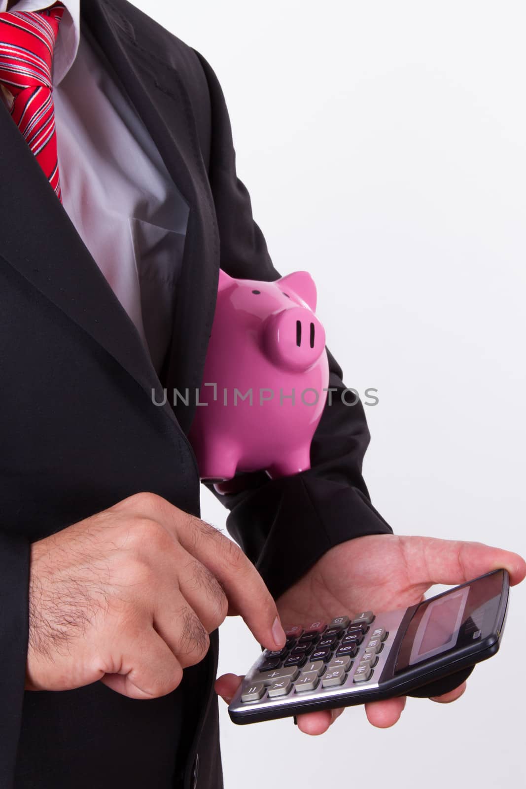 Businessman holding pink piggy bank and calculator,, pressing key with index finger, isolated on white background.