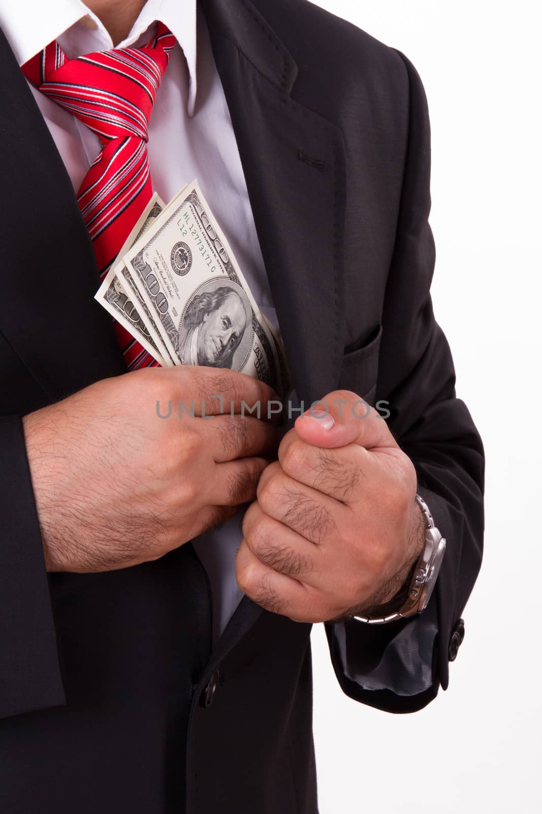 Businessman in a black suit putting hundred dollars in his pocket.