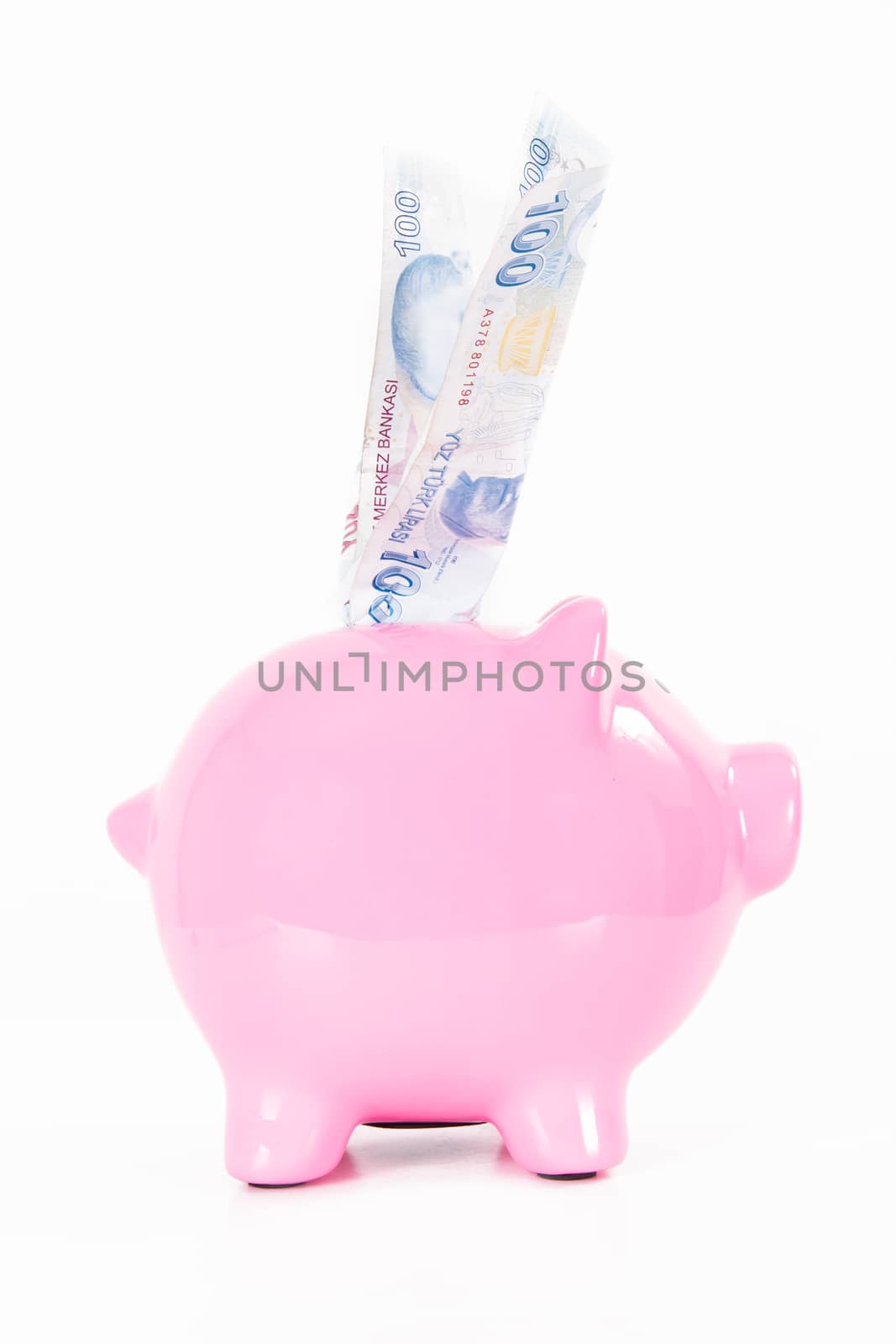 One hundred Turkish lira banknote in pink piggy bank, isolated on white background.