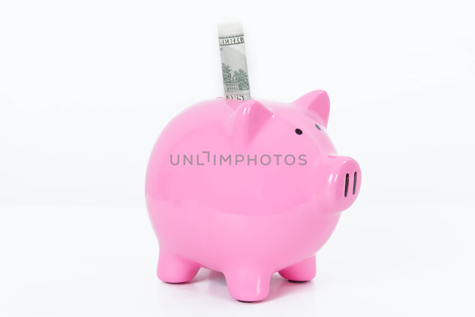 Pink piggy bank and one hundred dollar bill, isolated on white background.