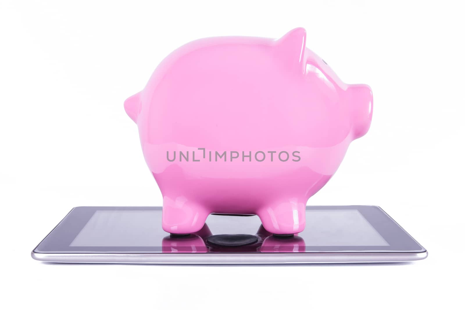 Pink piggy bank on tablet with blank screen, isolated on white background.