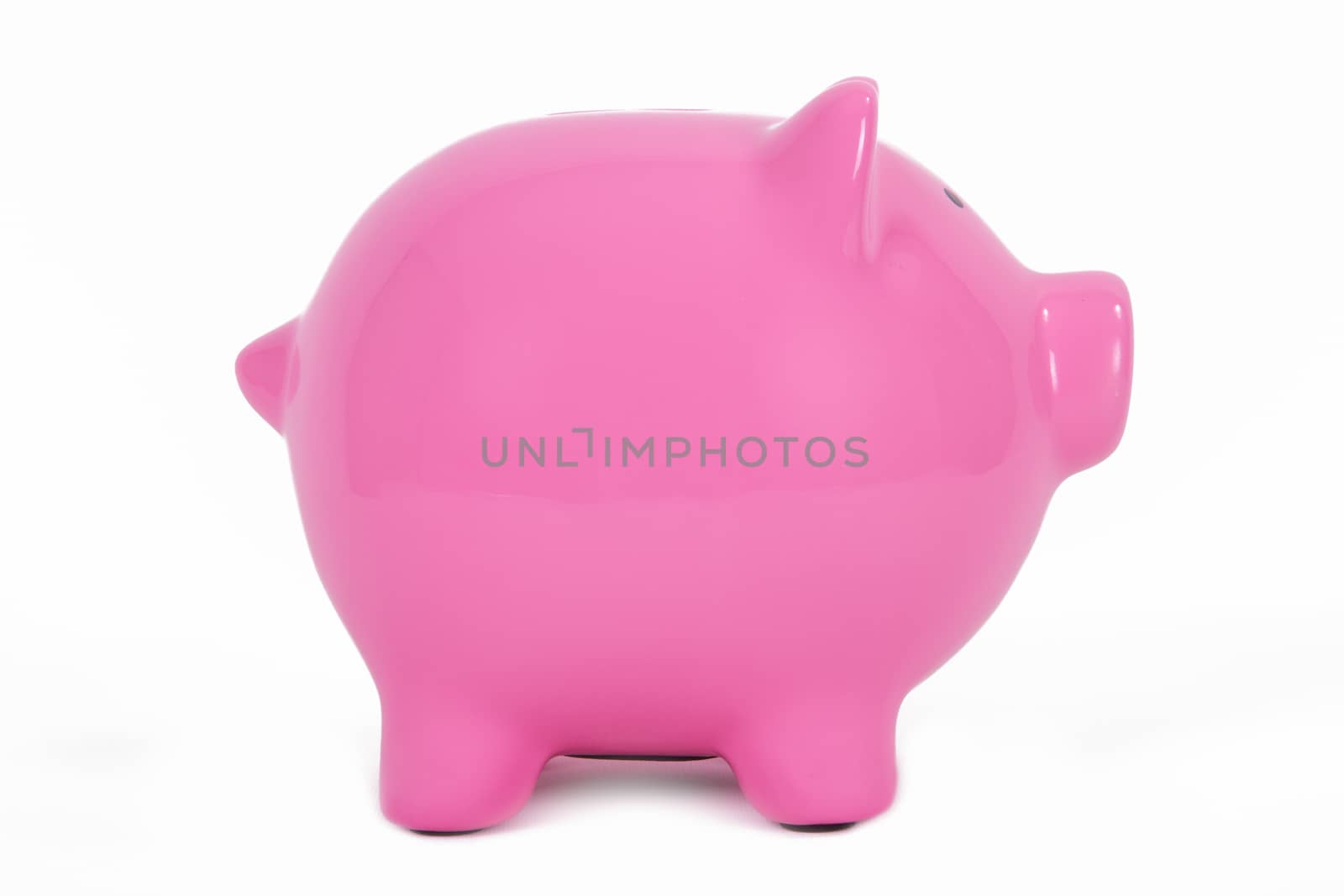 Pink piggy bank side view, isolated on white background.