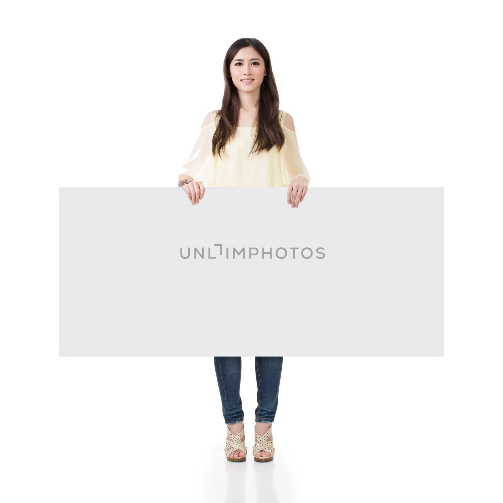Asian woman holding blank board, full length portrait on white background.