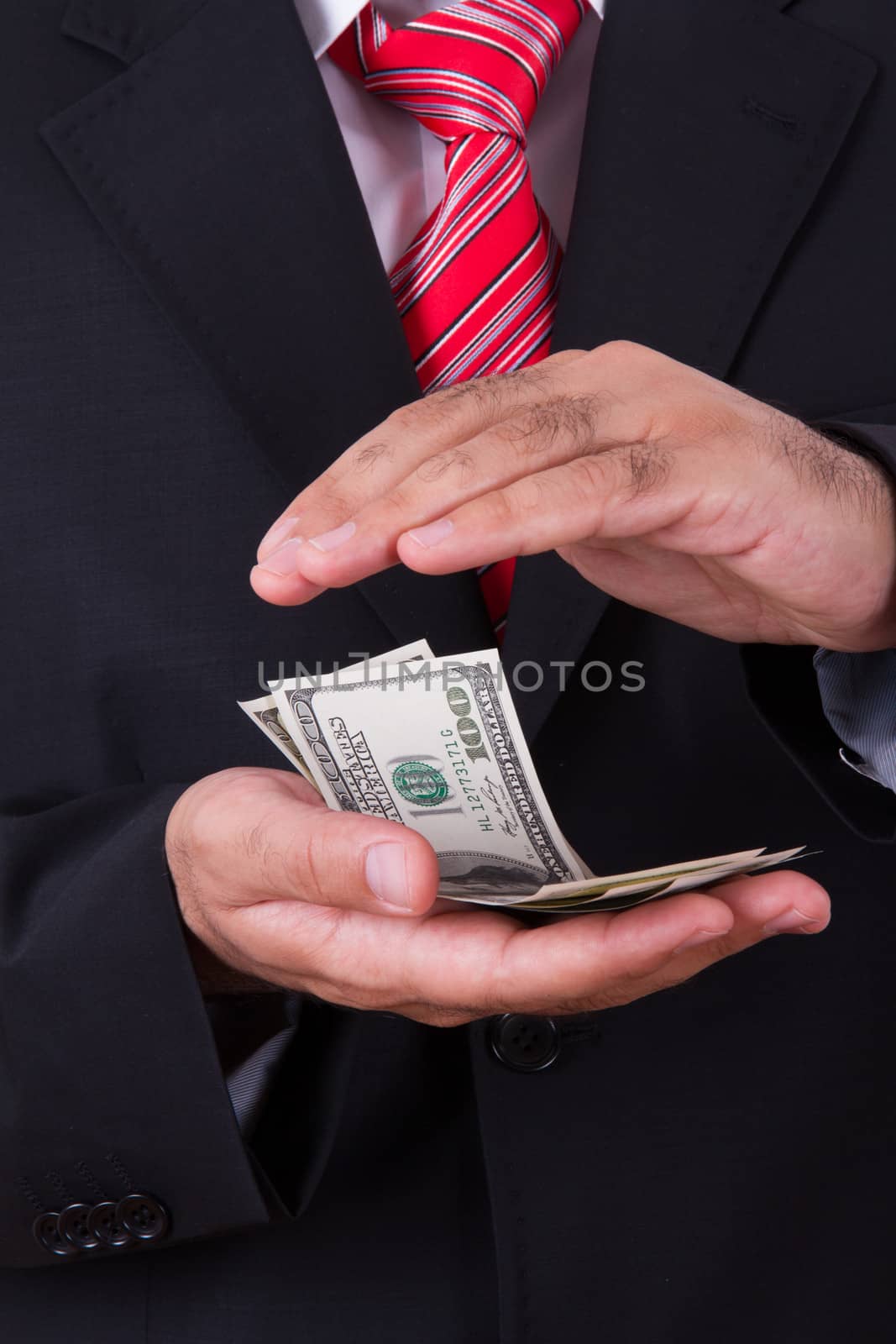 Businessman protecting, saving money between two hands.